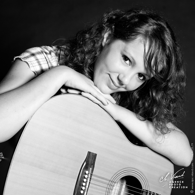 Portrait en noir et blanc d'une femme et sa guitare
