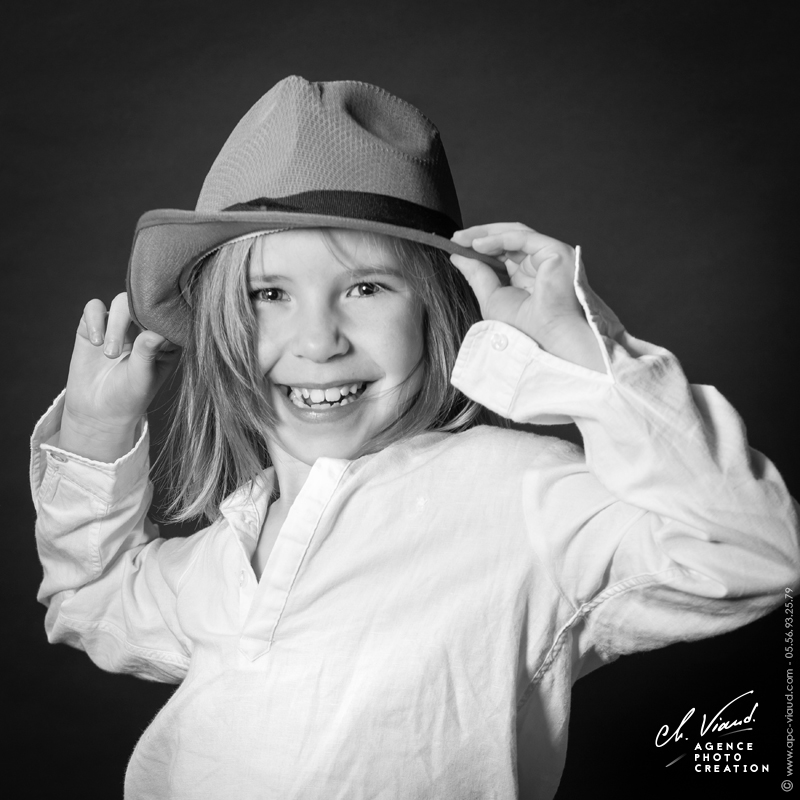 Portrait d'une petite fille en noir et blanc avec un chapeau
